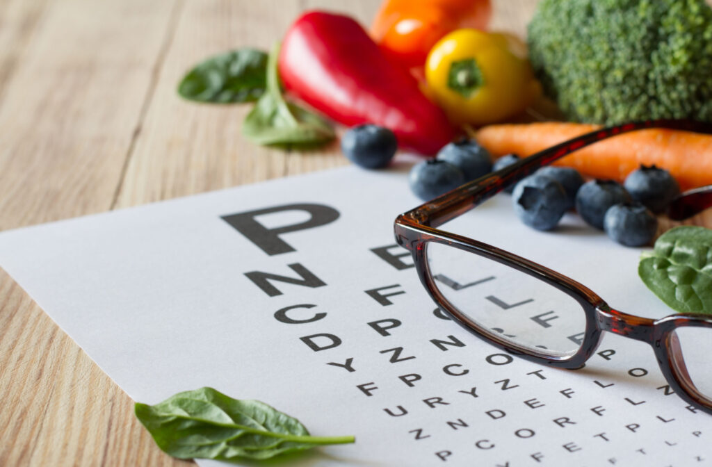 snellen chat and eyeglasses surrounded by antioxidant rich fruits and vegetables for eye health 