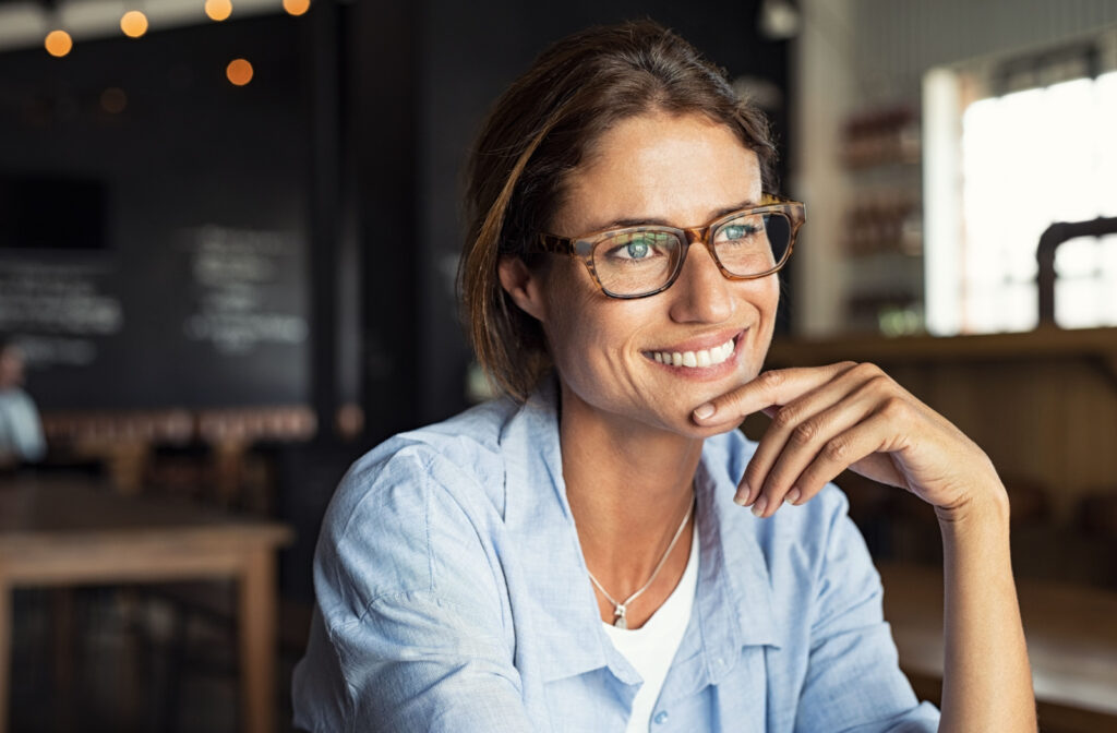woman wearing a pair of glasses while working at a cafe