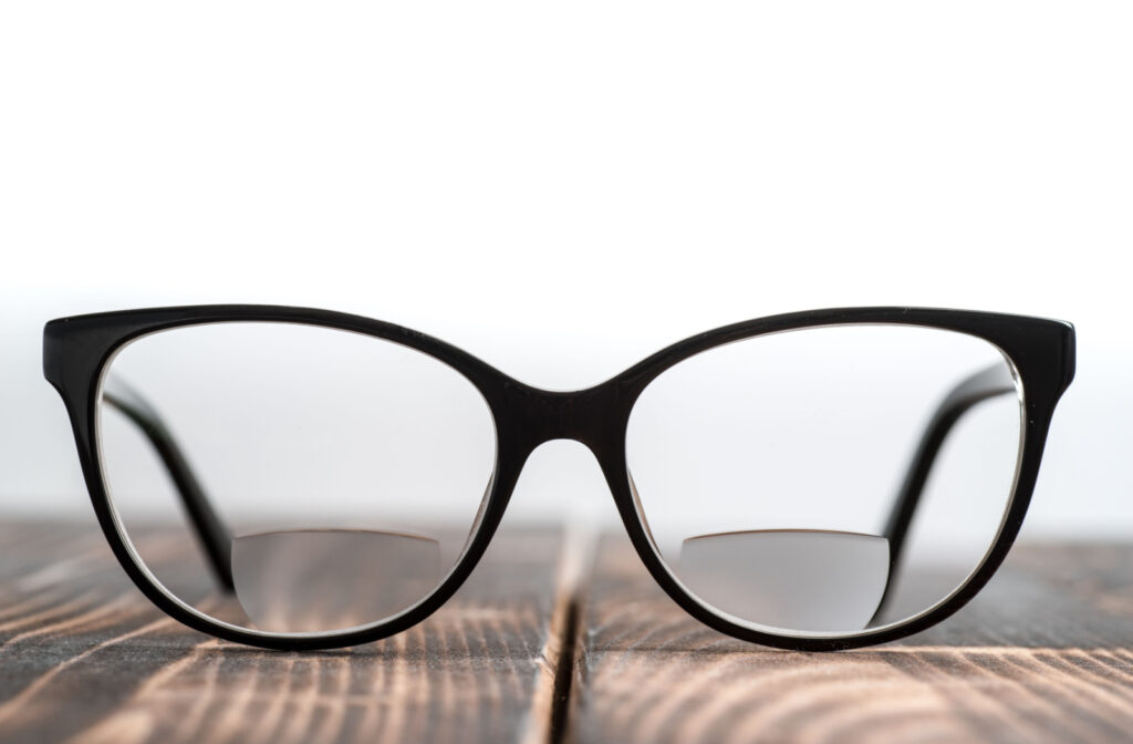 A pair of glasses with bifocal lenses resting on a table