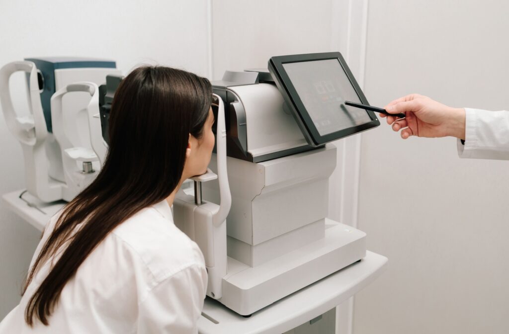A person leans into a machine that is a part of a regular comprehensive eye exam