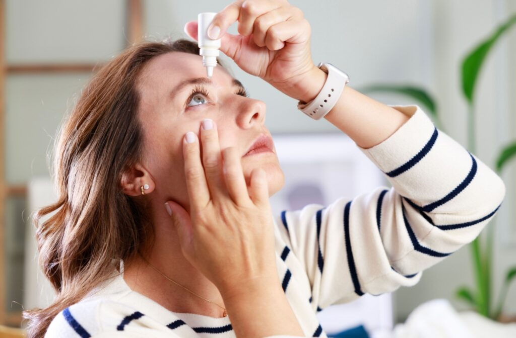 A person looking up as they put eye drops in their eye