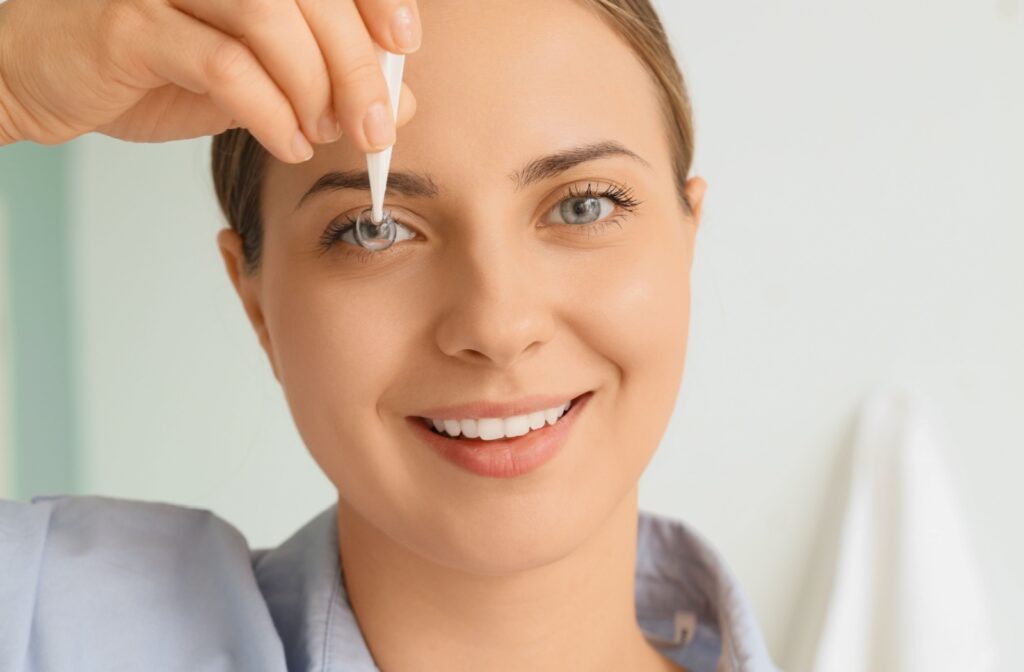 A person holds up a contact lens to their eye